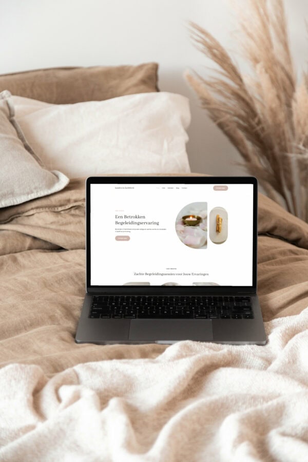 Laptop op bed met zachte kussens en decoratieve planten voor thuiswerk.