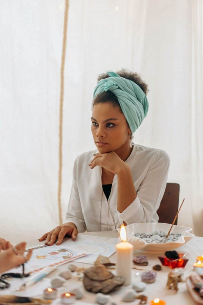 Vrouw mediteert met kaarsen en kristallen voor innerlijke rust en verbondenheid.